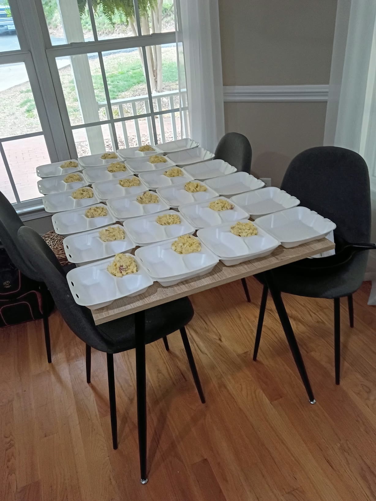 Open meal containers arranged across a table while portions are assembled